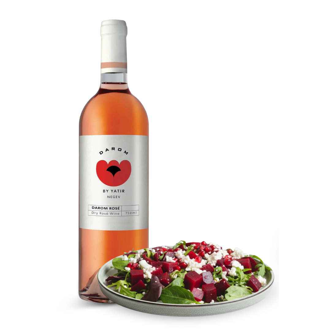 Bottle of Darom by Yatir rose wine with a plate of salad on a white background