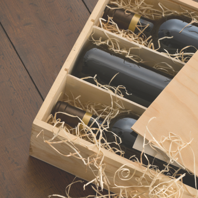 opened wooden wine box with wines and straw
