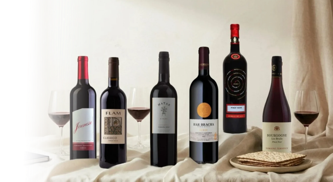 Collection of wine bottles on a table with glasses and bread