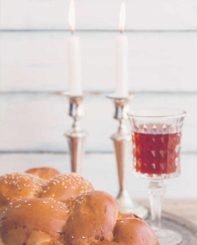 Shabbat ceremony composition with a fresh loaf of bread, candles and wine