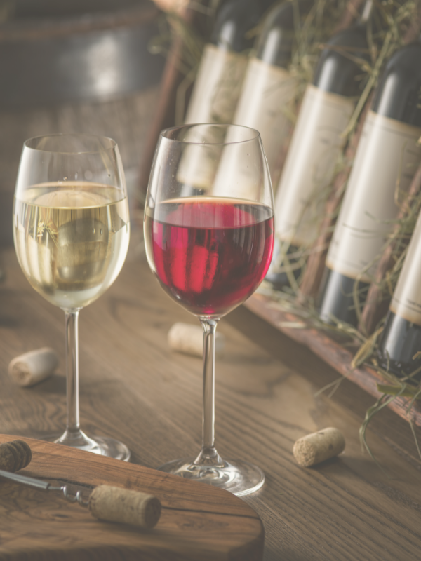 Two glasses of wine on a wooden table.