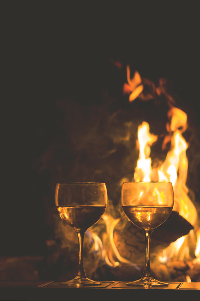 Glasses of wine beside a fire