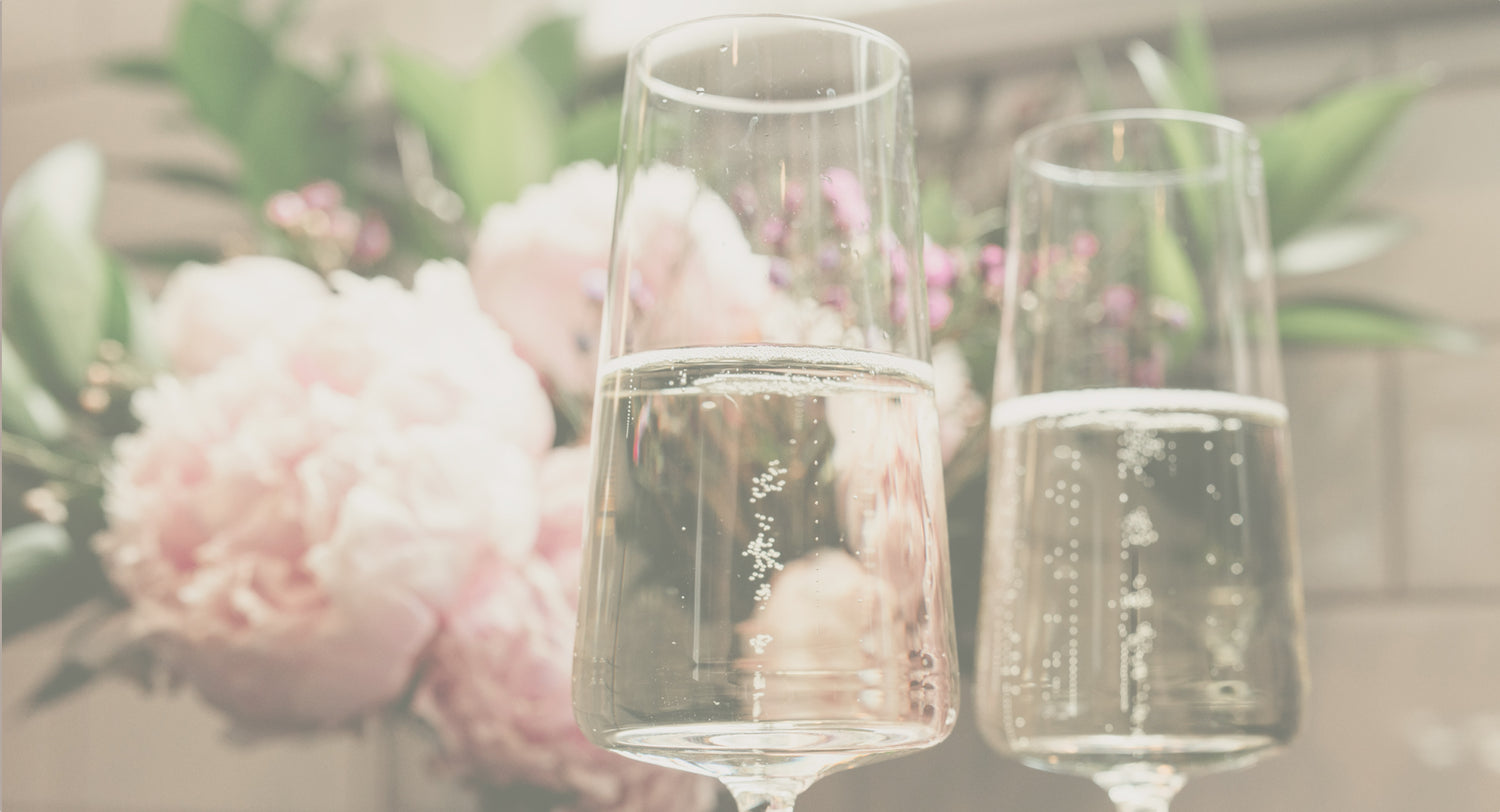 glasses of sparkling wine with a bouquet of pink flowers