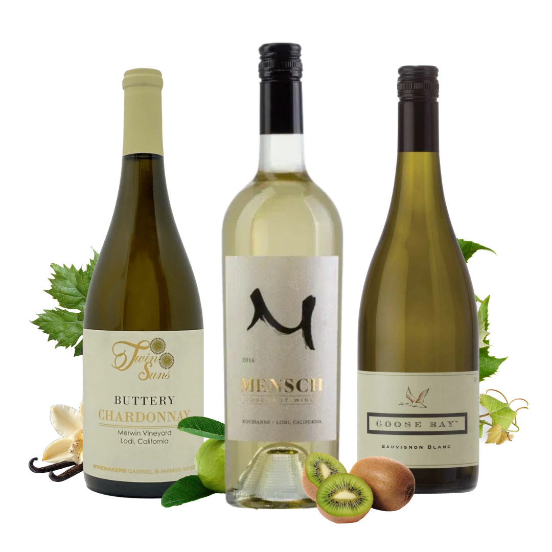 Three wine wines bottles arranged together on a white background with fruit and vanilla props: a Fruity Svin Buttery Chardonnay on the left, a central pale wine bottle with a large black monogram logo, and a Goose Bay Sauvignon Blanc on the right.