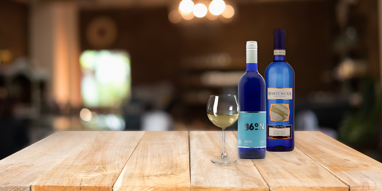 blue bottles of wine and wine glass sitting on a wooden table