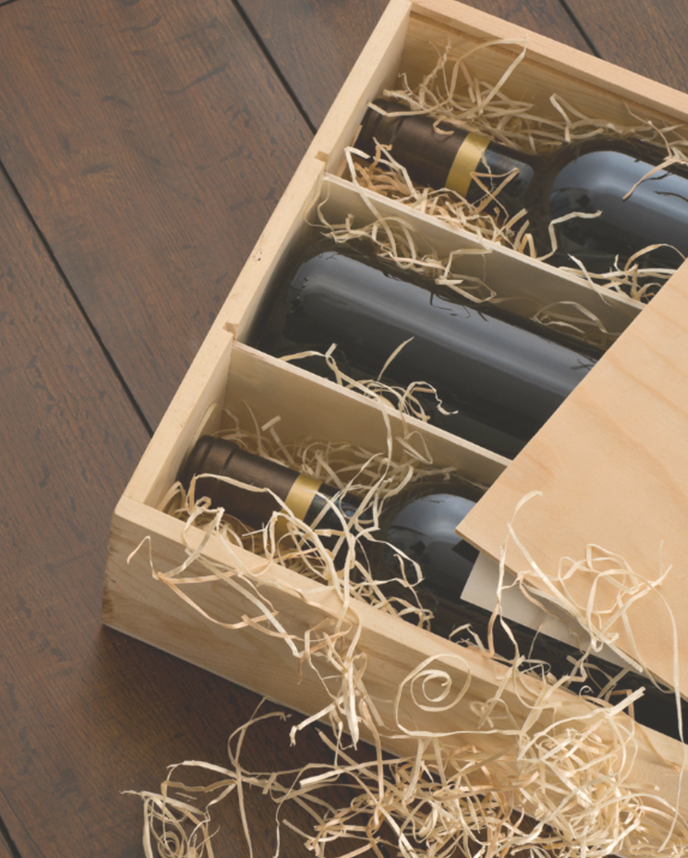 opened wooden wine box with wines and straw