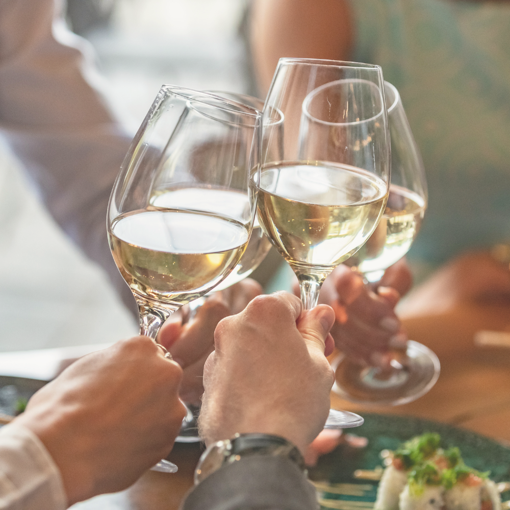 four friends giving celebratory toast with Bartenura Moscato white wine
