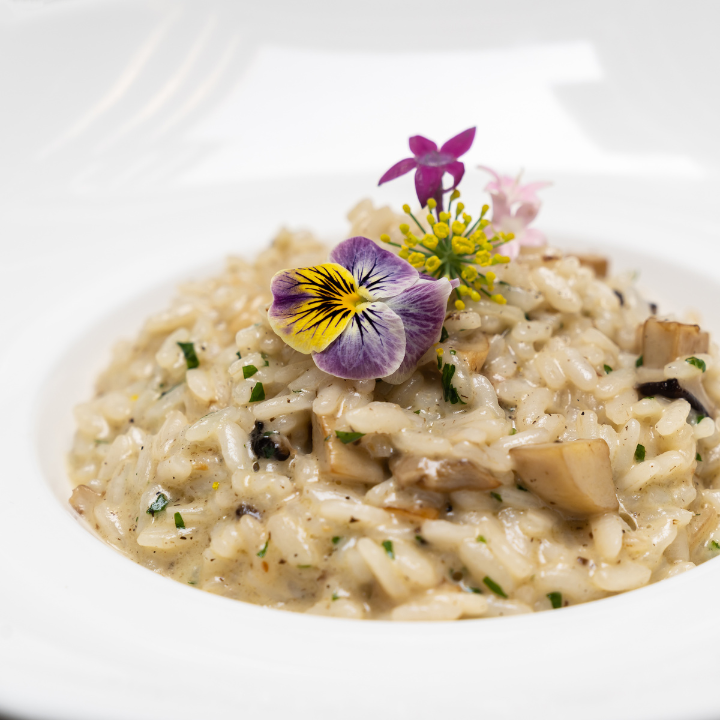 creamy cheese risotto with muschroom and truffle oil decorated with yellow and purple flower