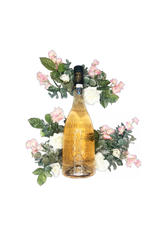 Bottle of Chateau Roubine Lion & Dragon Cru Classé Rosé surrounded by sprigs of white and pink flowers with green leaves