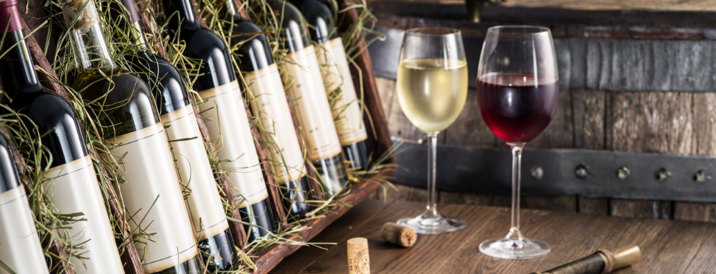 Wine bottles and glasses on a wooden table with a rustic background