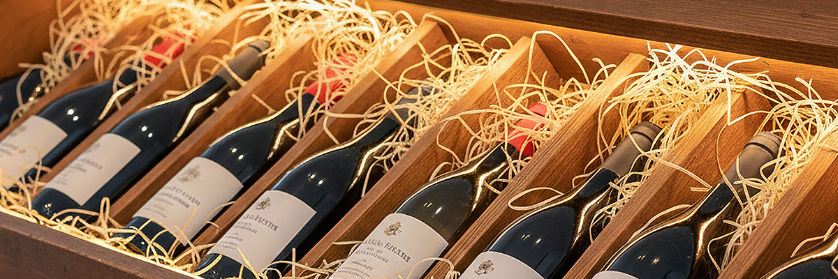 Wine bottles arranged in a wooden box with straw padding