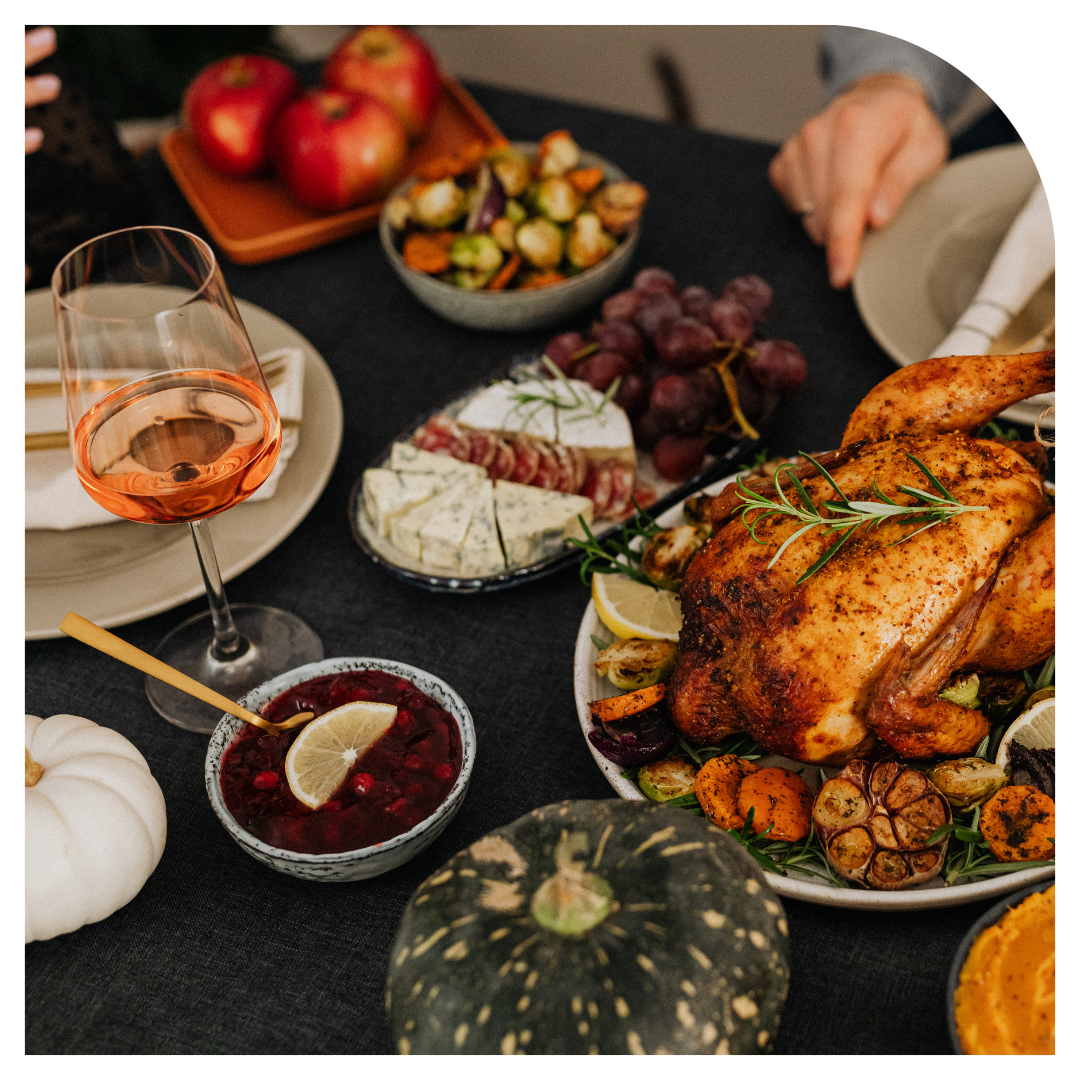 Thanksgiving dinner table with roasted turkey, pumpkins, and side dishes.